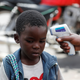 A health worker checks a child’s temperature in the Democratic Republic of the Congo, in this case for Ebola.